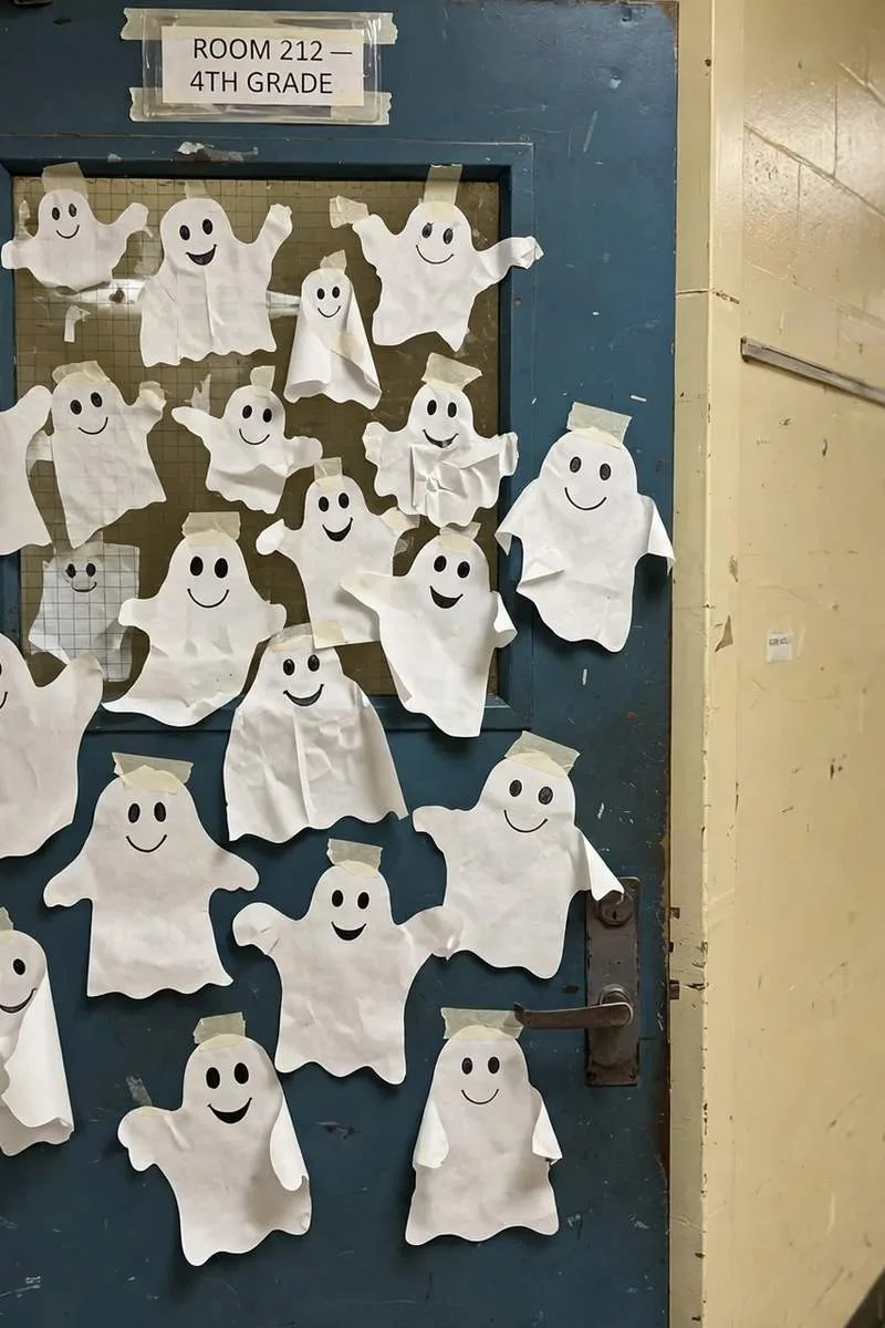 Ghostly welcome classroom door covered in friendly white paper ghosts