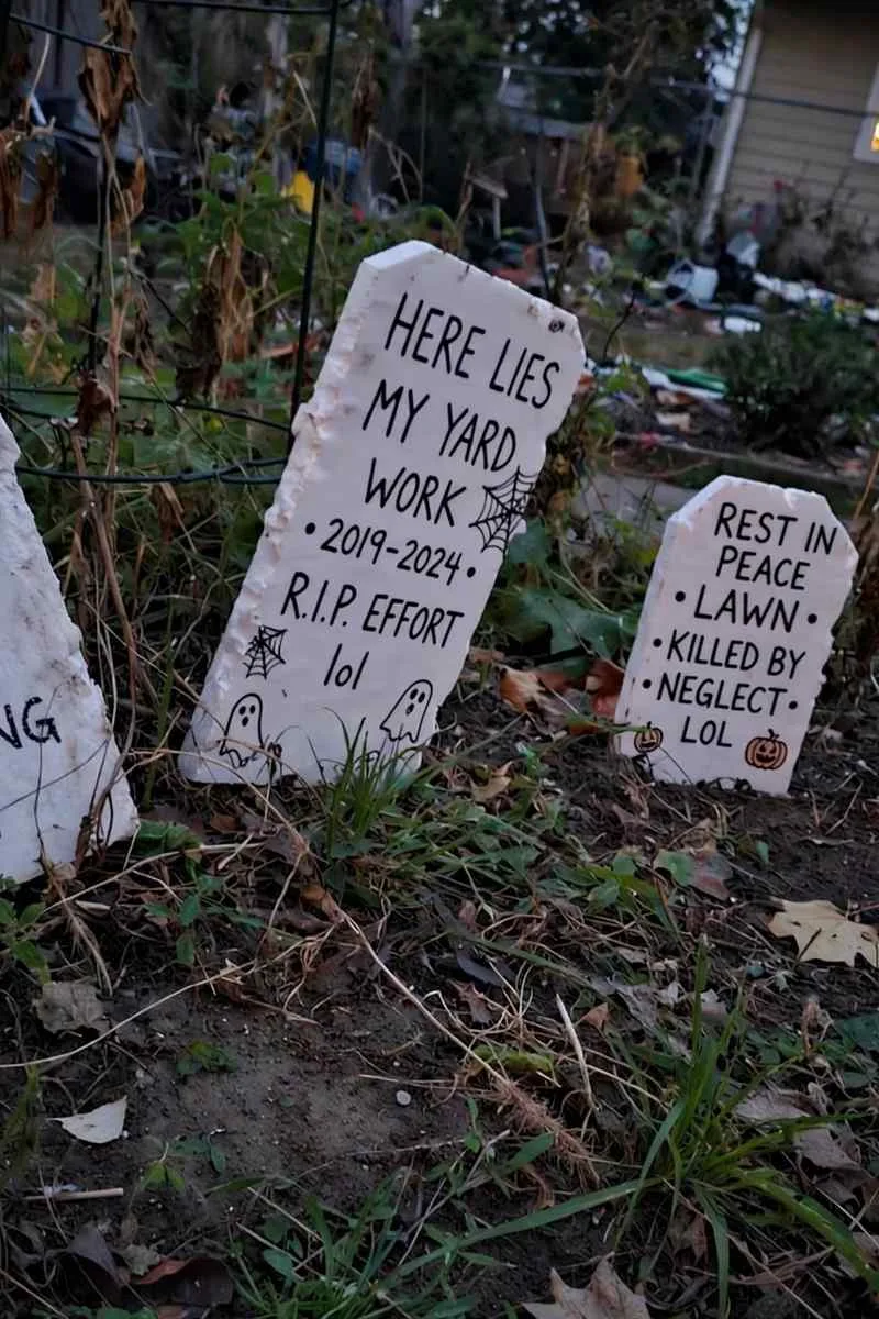 Foam tombstones with funny epitaphs in a flower bed