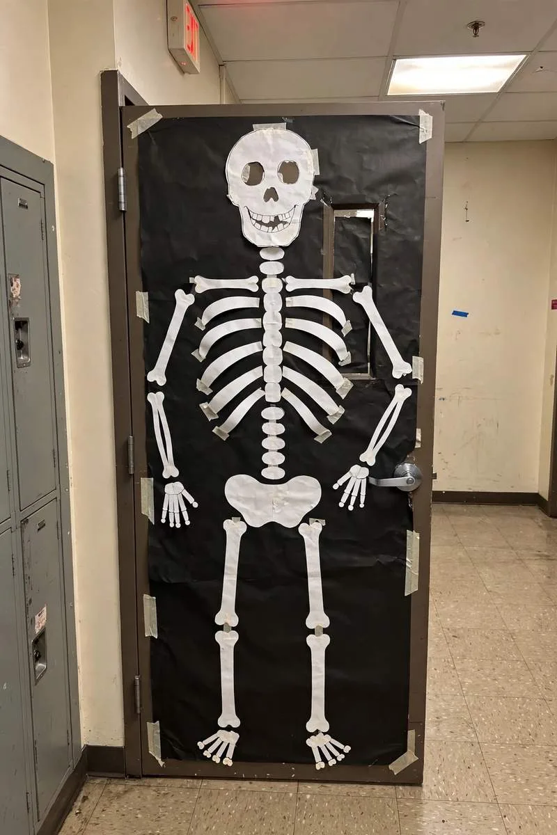 Friendly skeleton classroom door with white paper bones on black