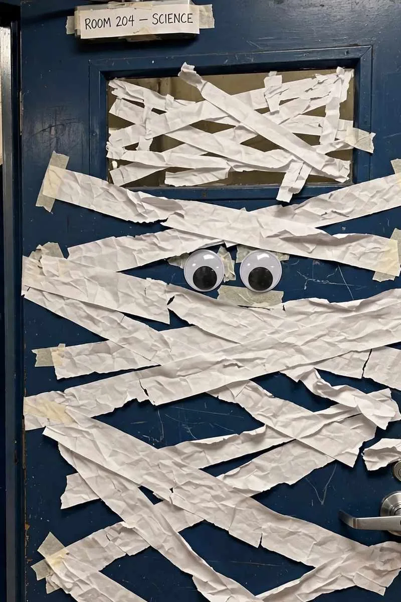 Mummy classroom door wrapped in white paper strips with googly eyes
